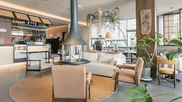 Un interior moderno con una zona de bar, asientos y una chimenea central.