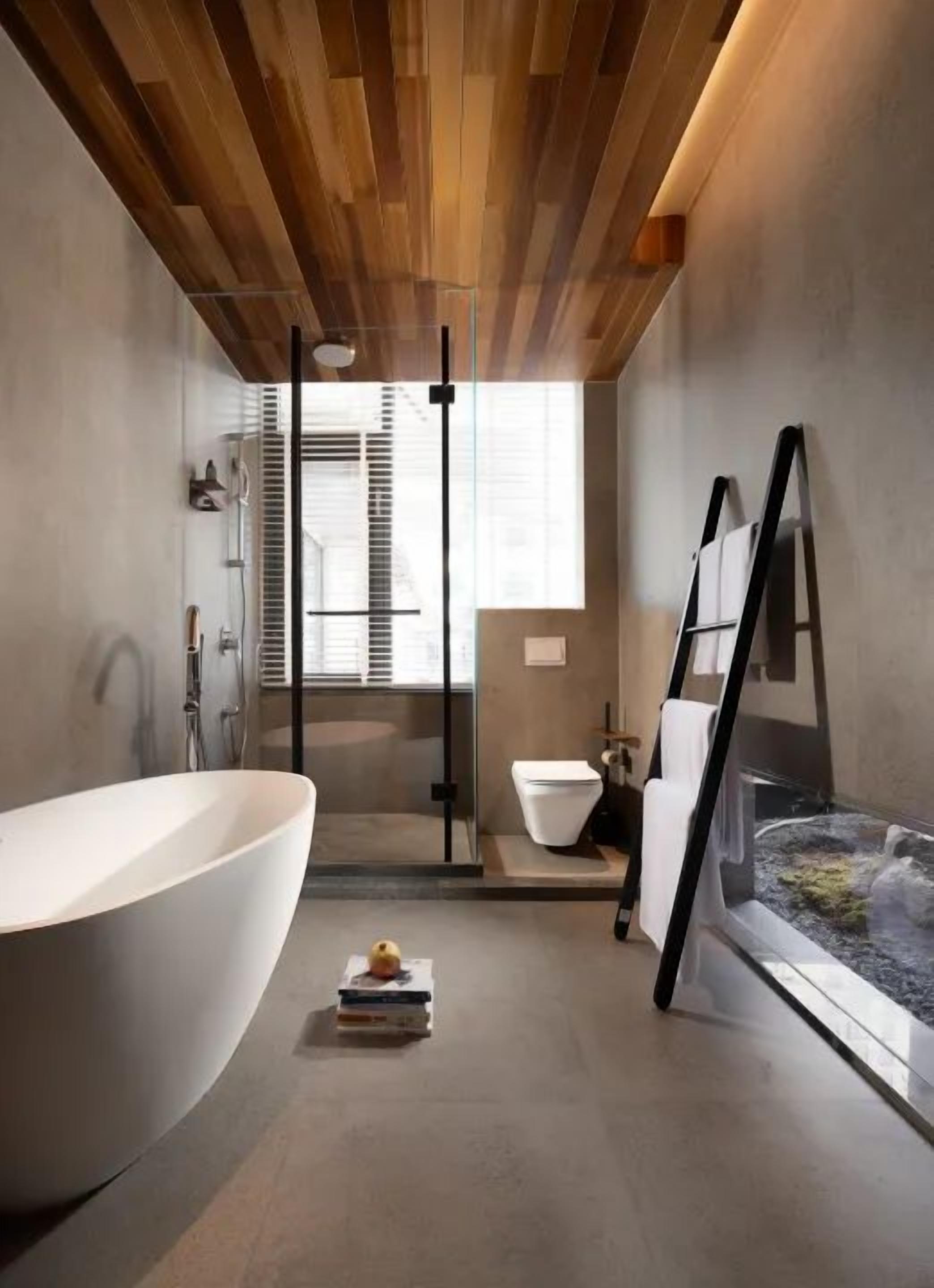 A modern bathroom with a freestanding bathtub, a glass shower enclosure, and a small indoor garden.