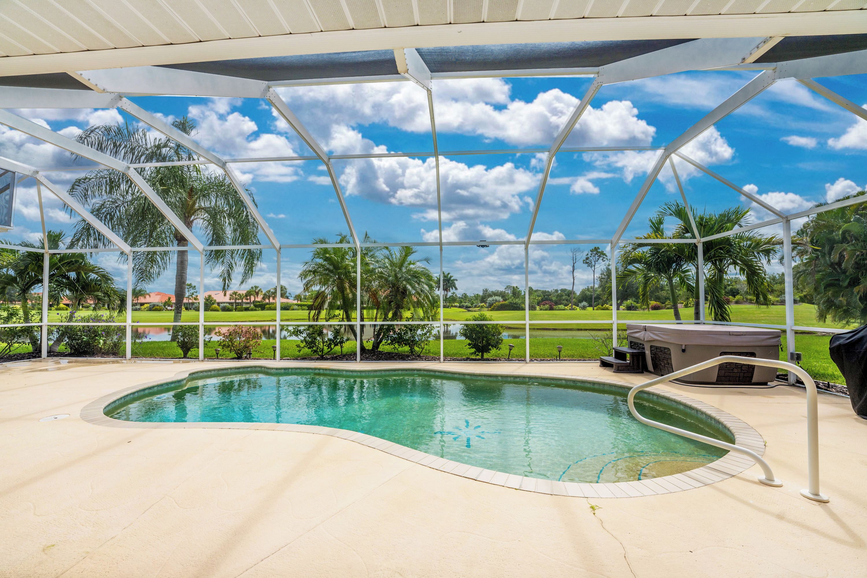 Una piscina con vistas a un campo de golf y palmeras.
