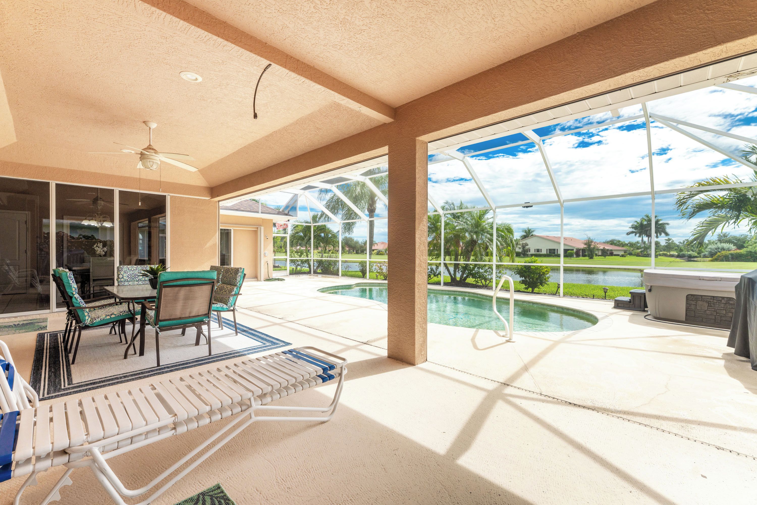 Un espacio exterior cubierto con piscina, sillas de descanso y vistas a un campo de golf.
