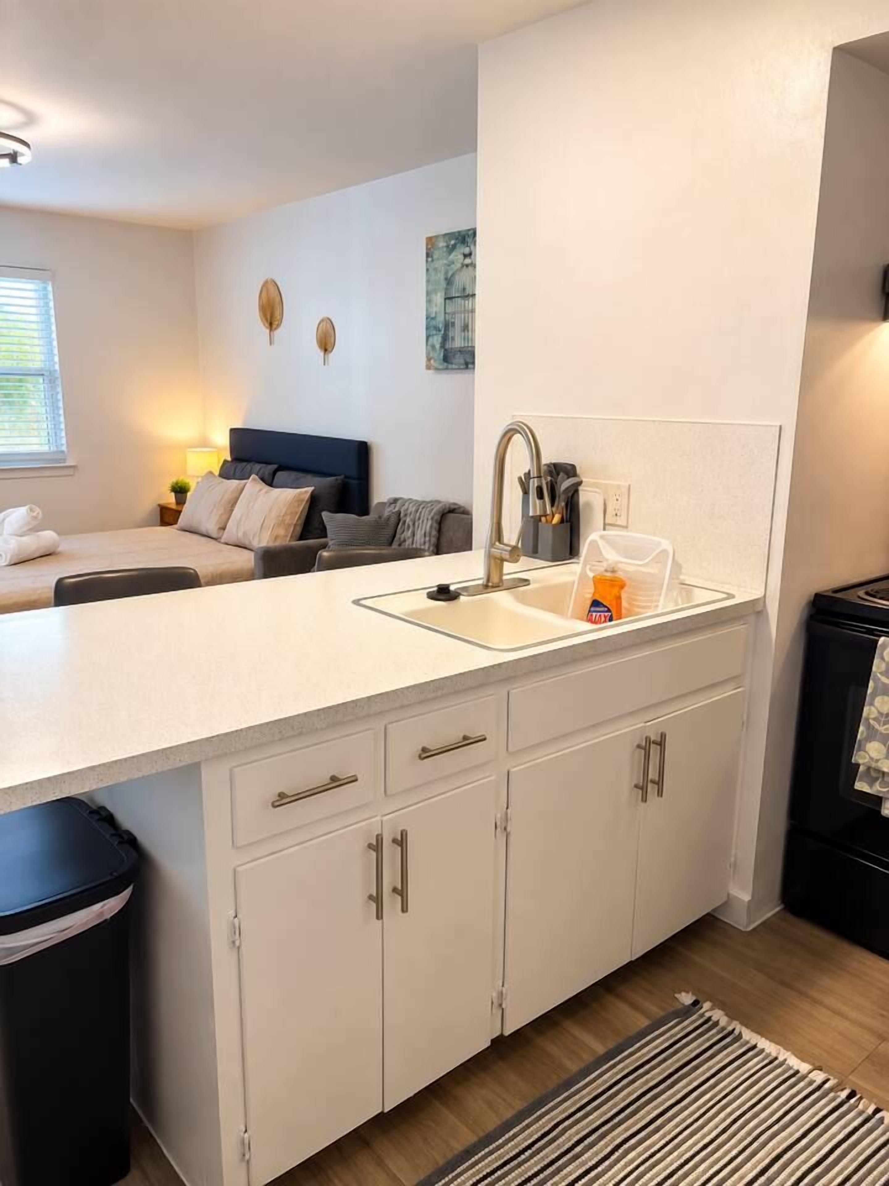 A modern kitchen with a sink, cabinets, and a countertop.