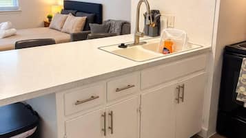 A modern kitchen with a sink, cabinets, and a countertop.
