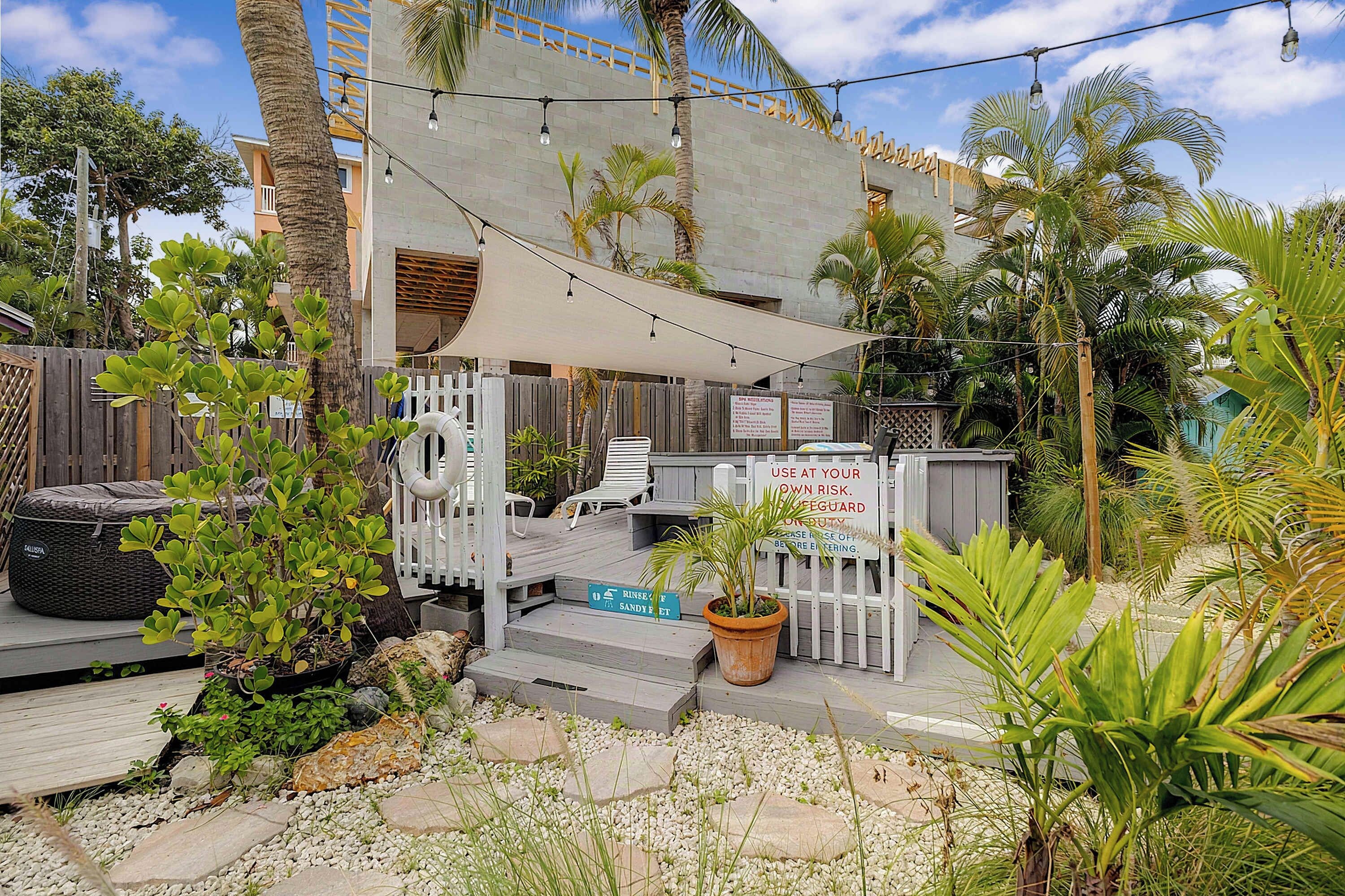 Terassi, jossa on ulkotila istumiseen, kyltin, jossa on merkintä uimavalvojasta, ja kyltin, jossa ilmoitetaan, että alue on yksityisaluetta.
