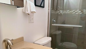 A bathroom with a sink, toilet, and glass shower enclosure. - Beautifully Set Up 2BR Space (Chicago)
