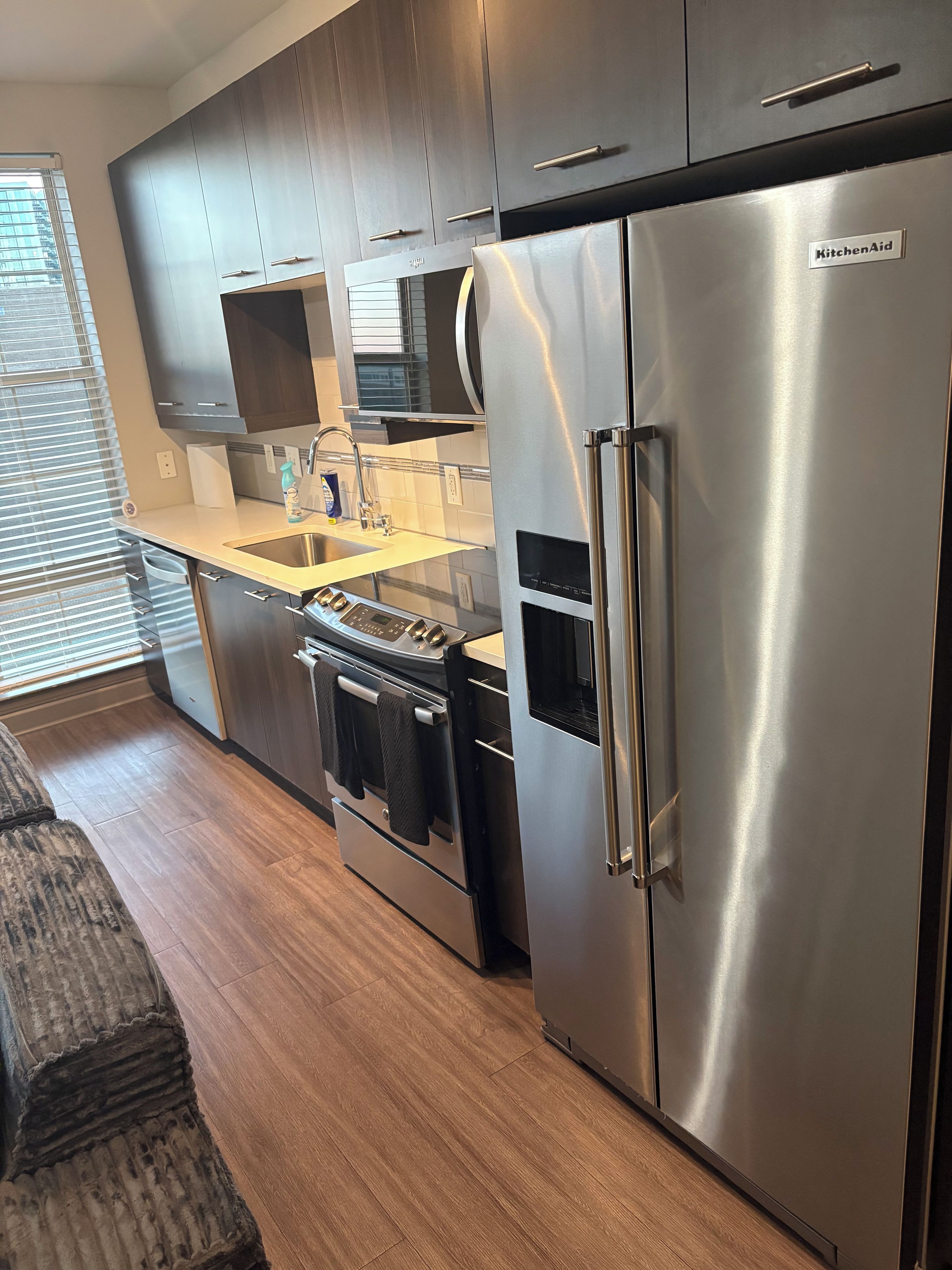 A modern kitchen with stainless steel appliances, wooden cabinets, and a built-in oven.