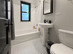 Een badkamer met een bad, een wit wastafel en een toilet.