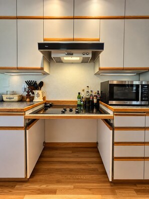 A modern kitchen with a built-in microwave, a gas stove, and various kitchen utensils. - Hot tub, private bridge, large patio, and secret garden property to explore (Moscow)