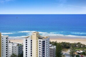 A beachfront hotel with multiple floors, a sandy beach, and the ocean in the background. - High-Rise 2-Bed Apartment in Surfers Paradise (Surfers Paradise)