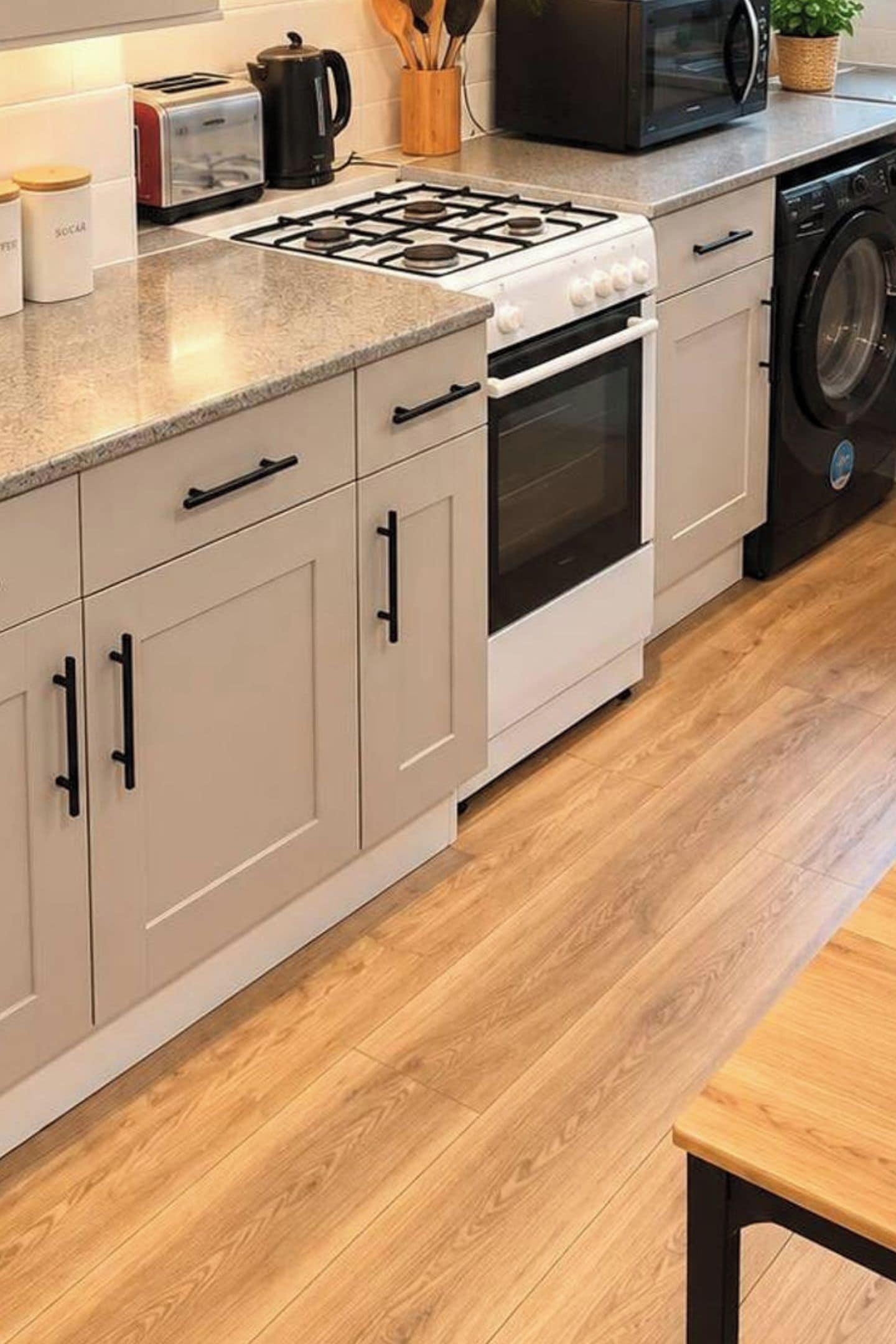 Una cocina equipada con estufa a gas, horno, microondas y lavadora.