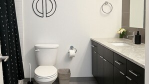 A modern bathroom with a toilet, bidet, and a sink with a mirror. - Chic Studio in Historic Hyde Park – Walk to Campus (Chicago)