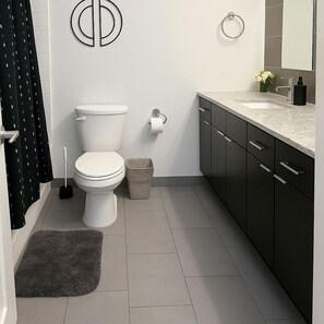 Un bagno moderno con toilette, bidet e lavandino con specchio.