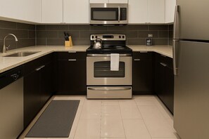 Una cucina moderna con elettrodomestici in acciaio inossidabile, tra cui un forno a microonde, un forno e un frigorifero.