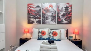 Una habitación de hotel con una cama, dos lámparas de noche y tres cuadros colgados en la pared.