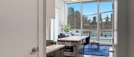 Eine moderne Küche mit Einbauofen und Essbereich mit großem Fenster.