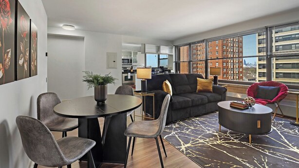 A modern living room with a sofa, chairs, a coffee table, and a dining table. - Sunlit 2BR - Fully Furnished & Spacious Apartment (Chicago)