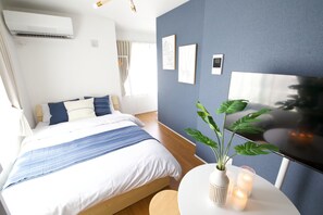 A modern bedroom with a bed, bedside table, and a potted plant. - Lamarie Haneda 403 (Ota Ku)
