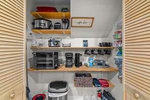 A kitchen with various appliances and storage shelves. - Serenity by the Creek (Robbinsville)