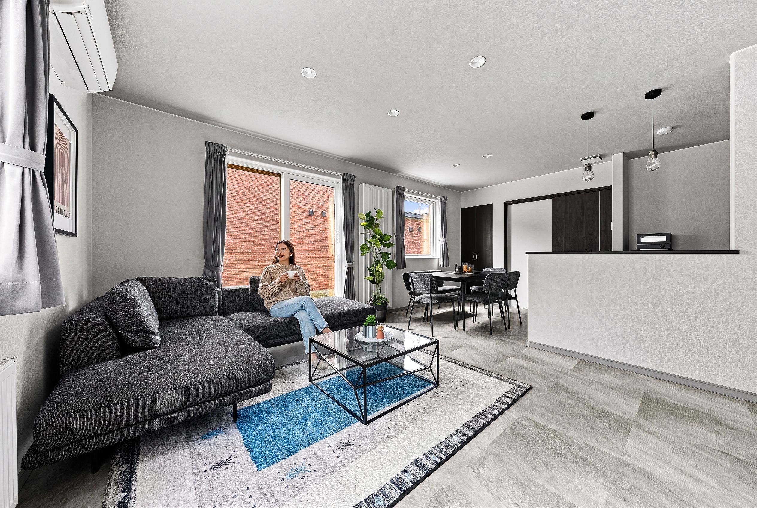A modern living room with a sectional sofa, a coffee table, and a dining area with chairs.