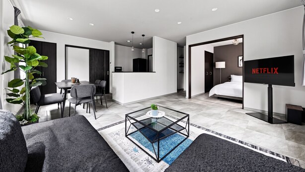 A modern hotel room with a living area, a dining space, and a bedroom. - BRIC (Asahikawa)