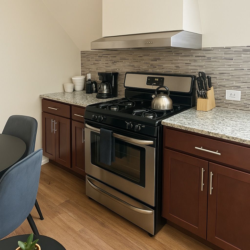 A modern kitchen with stainless steel appliances, a granite countertop, and wooden cabinets.