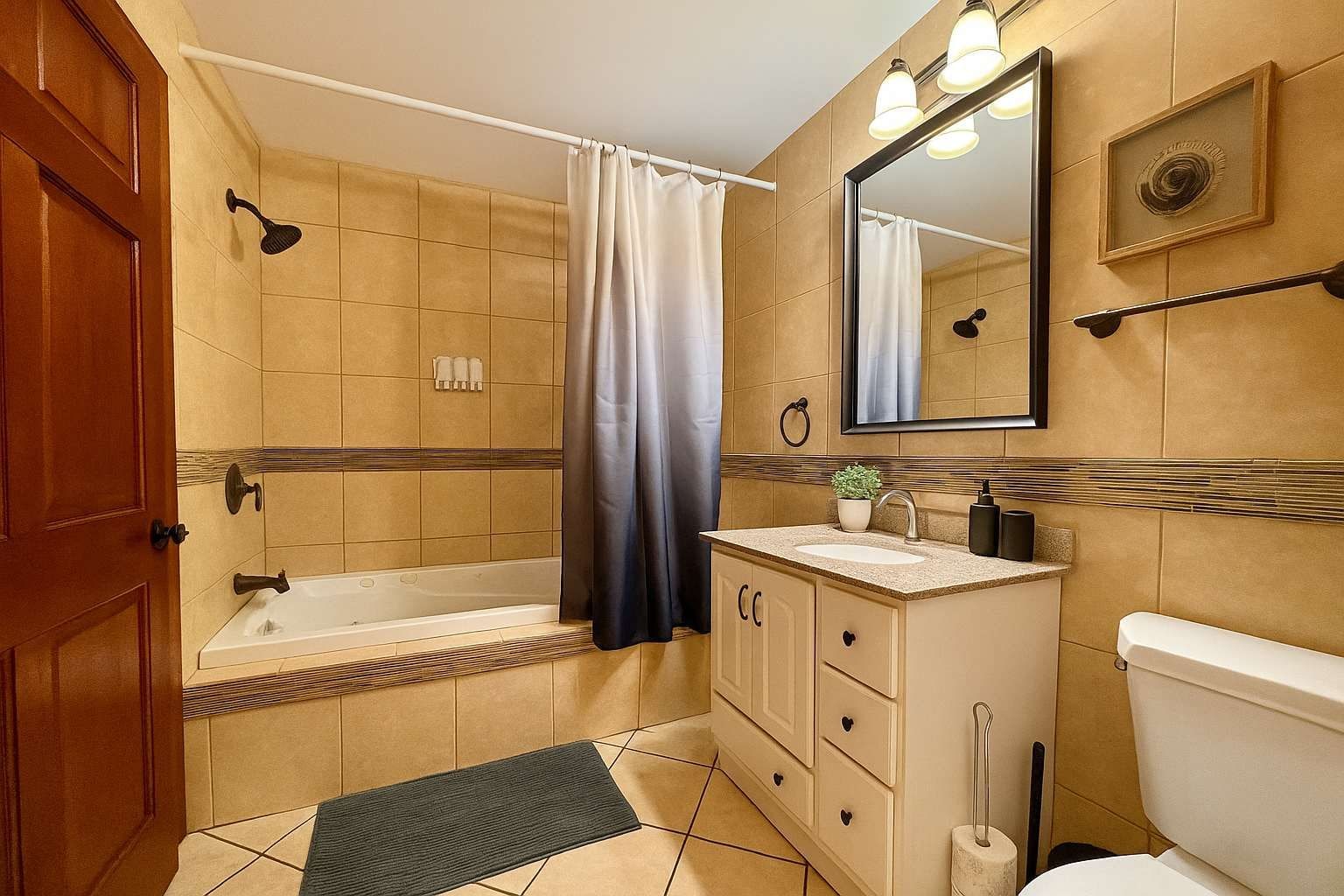 Une salle de bain avec une baignoire, des toilettes, un lavabo et un miroir.