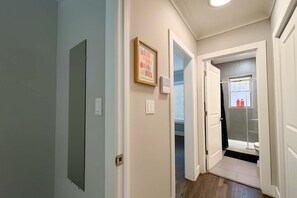 A hallway with a door leading to a bathroom. - 1BR Stylishly Apt in Lakeview (Chicago)