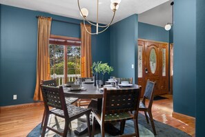 A dining room with a round table, four chairs, and a chandelier. - Heated Pool | Sauna | Hot Tub | Theater | Games (Kalkaska)