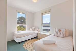 Ein Hotelzimmer mit zwei Betten, einem Fenster und Blick ins Freie.