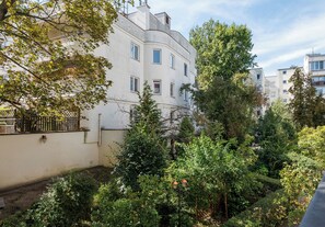 A residential building with multiple windows, a gated entrance, and surrounding greenery. - National Stadium Prime Location Studio (Warszawa)