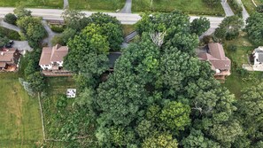 An aerial view of a residential area with houses, roads, and dense greenery. - Hot Tub | Sauna | Sleeps 6 (Canandaigua)
