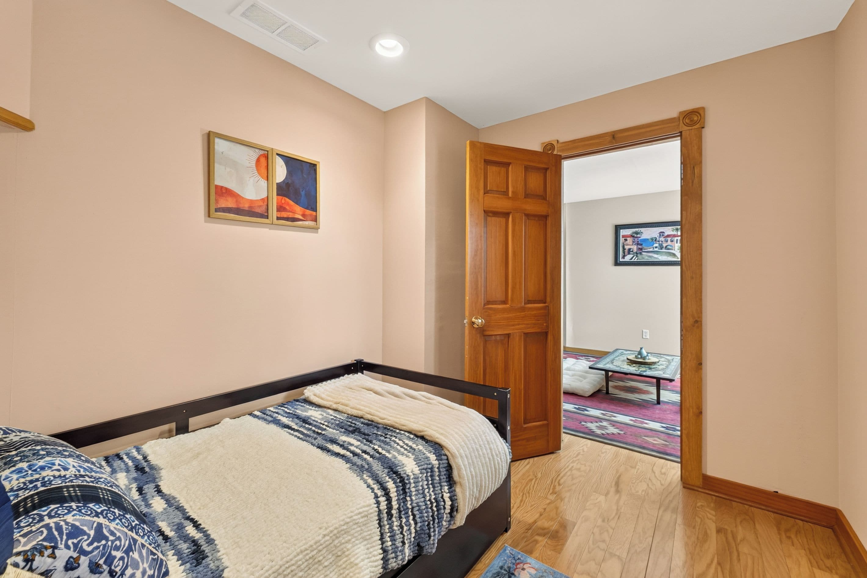 Un dormitorio con una cama, una puerta y un pasillo que conduce a otra habitación.