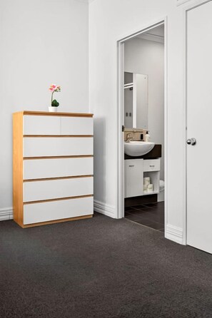 Ein Badezimmer mit einem weißen Schrank, einem Waschbecken und einem Spiegel.