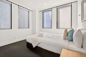 A hotel room with a bed, a bedside table, and a window with a view. - Stylish 1BR in the Heart of Auckland Zodiak Stays (Auckland)