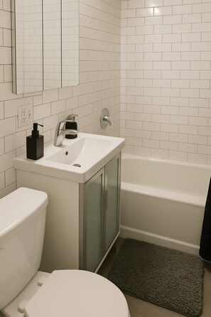 A bathroom with a toilet, sink, and bathtub.