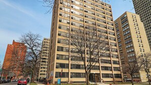 Un edificio de varios pisos con fachada uniforme, ventanas grandes y techo plano.