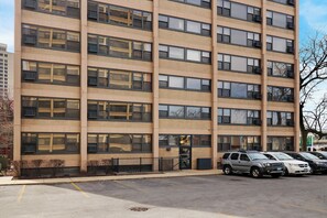 A multi-story building with a parking lot in front.