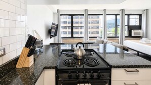 Una cocina moderna con estufa, hervidor y bloque de cuchillos.