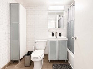 Uma casa de banho moderna com sanita, lavatório e zona de duche.