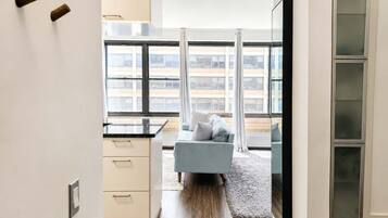 Eine moderne Wohnung mit Küche, einem Wohnbereich mit Sofa und großen Fenstern.