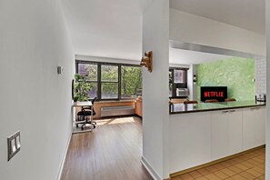 Una cocina moderna con un ventanal grande, señalización de Netflix integrada y un comedor con banco.