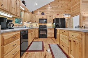 Une cuisine avec des meubles de rangement en bois, un four à micro-ondes, un réfrigérateur et un lave-vaisselle.