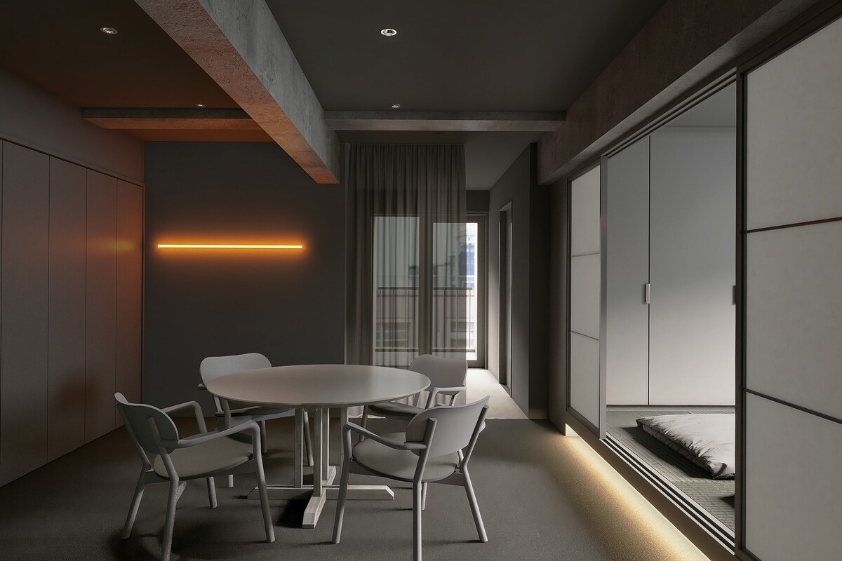 A modern interior with a round table and four chairs, a large window with curtains, and a sliding door.