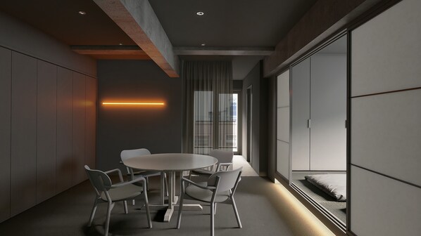 A modern interior with a round table and four chairs, a large window with curtains, and a sliding door.