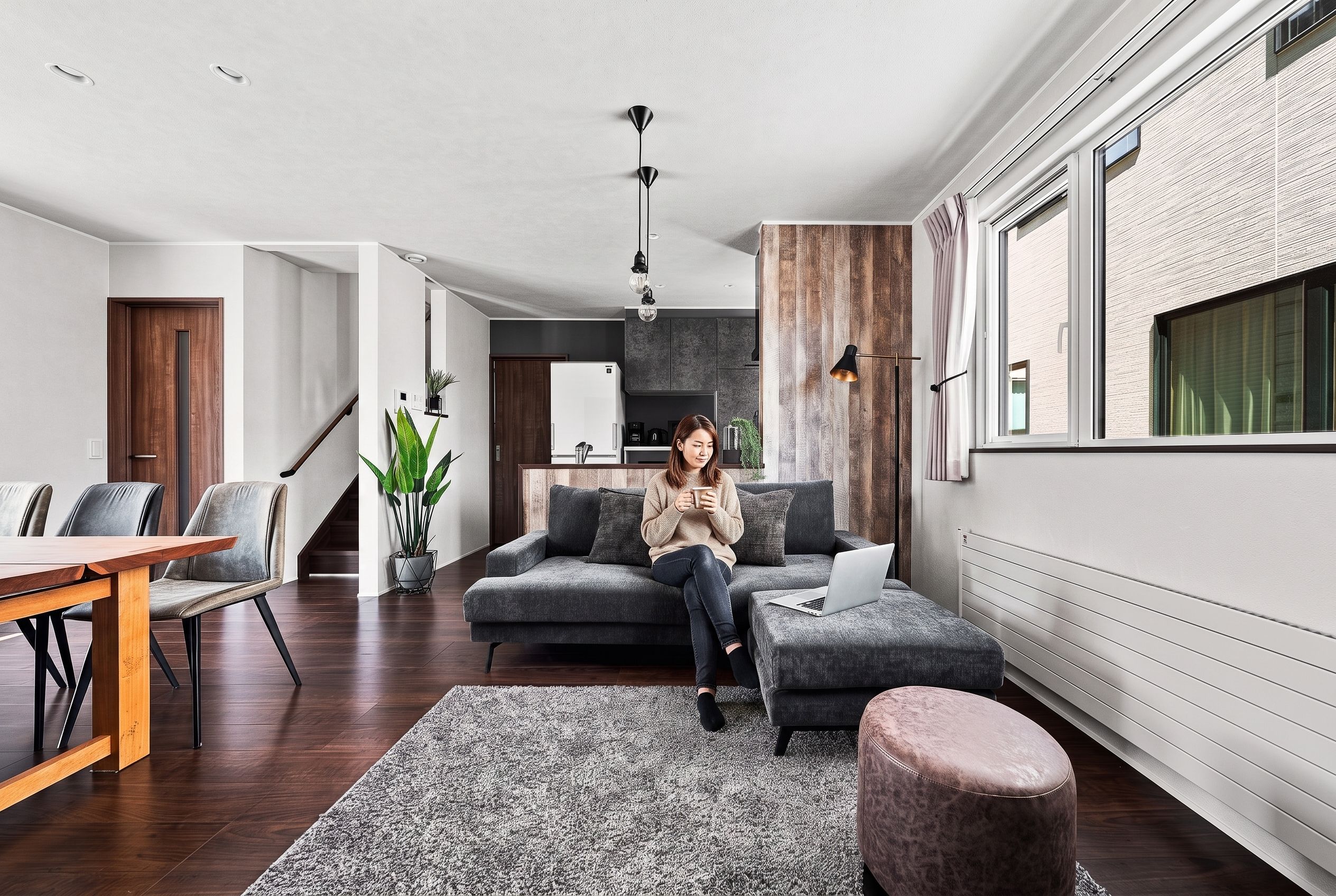 Un salon moderne comprenant un canapé, une table basse et un coin repas avec des chaises et une table en bois.
