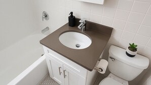 A bathroom with a bathtub, a sink, and a toilet. - Hyde Park Trendy Studio Apartment in Good Spot (Chicago)