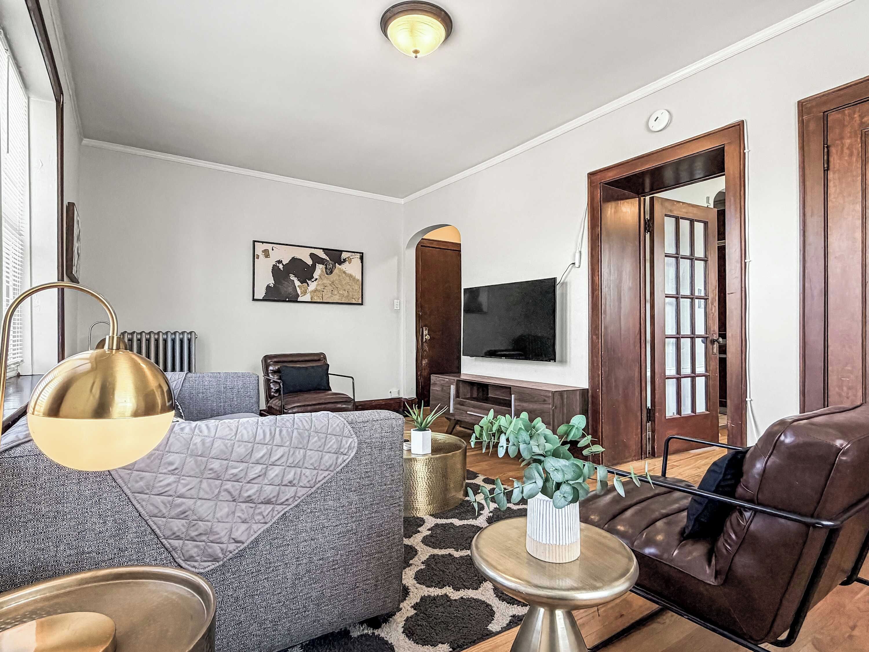Una sala de estar moderna con un sofá, una mesa de centro, un televisor y una chimenea.