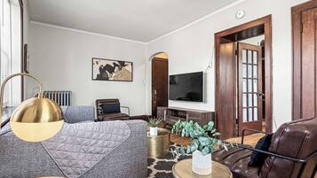 Una sala de estar moderna con un sofá, una mesa de centro, un televisor y una chimenea.