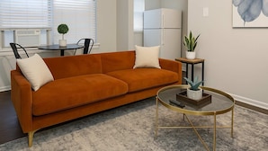 A living room with a sofa, a coffee table, and a potted plant. - 1BR Chic Apt in Downtown Chicago (Chicago)