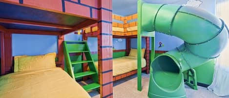 A children's play area with bunk beds, a slide, and a ladder.