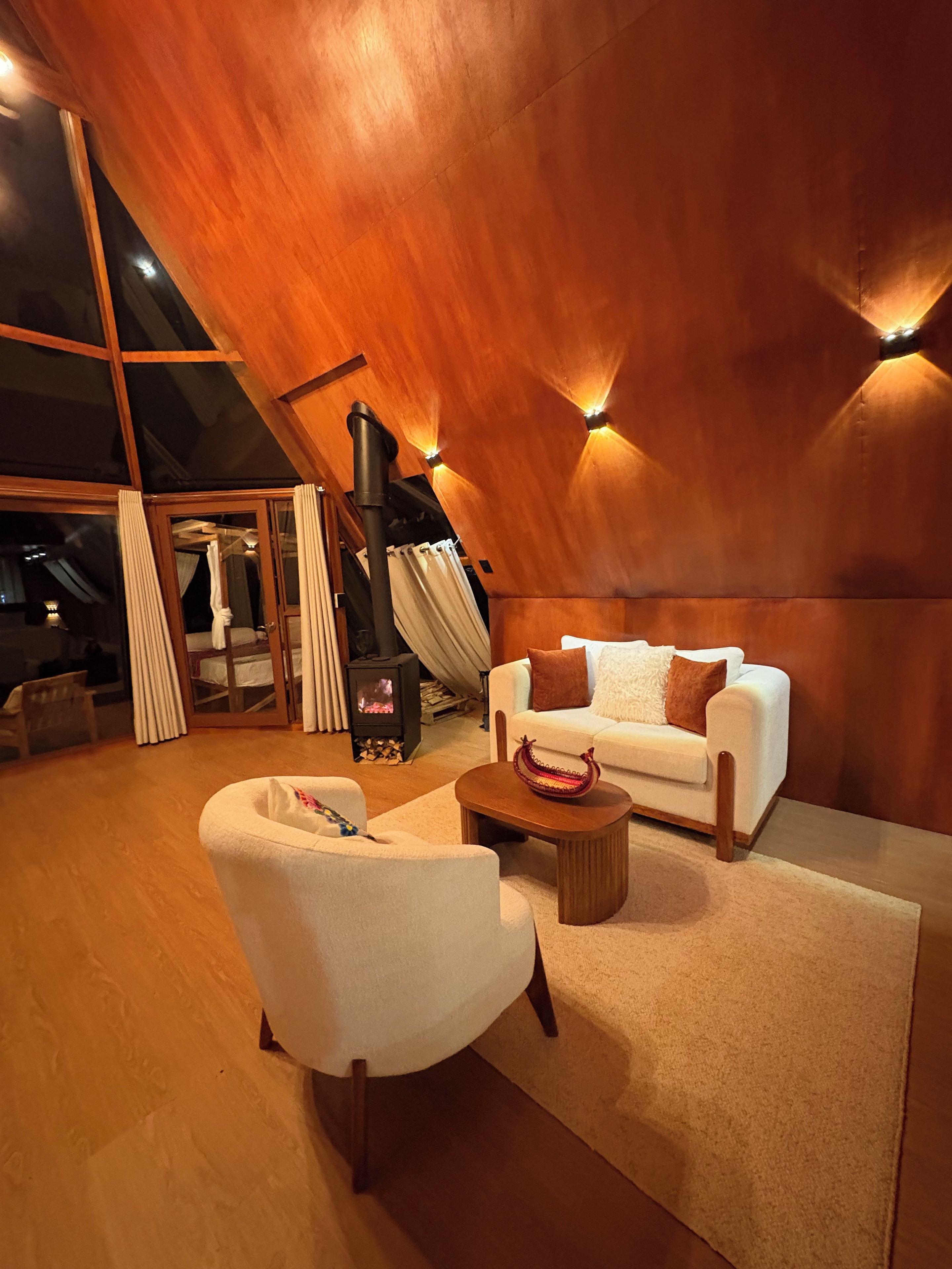 A modern interior with a white sofa, a wooden coffee table, and a fireplace.